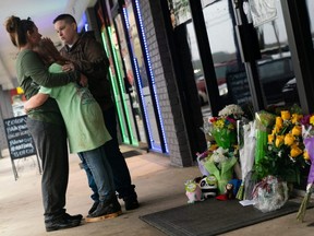 People hug outside Youngs Asian Massage where four people were shot and killed, in Acworth, Ga., Wednesday, March 17, 2021.