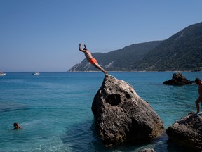 A man dives at Agios Nikitas beach, following the easing of measures against the spread of COVID-19, on the island of Lefkada, Greece, July 25, 2020.