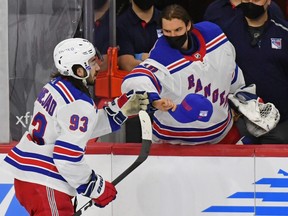 New York Rangers goaltender Alexandar Georgiev (40) tries to give centre Mika Zibanejad (93) a hat after he scored his third goal of the game against the Philadelphia Flyers on March 25, 2021.