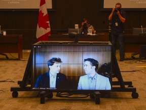 Marc Kielburger, screen left, and Craig Kielburger, screen right, appear as witnesses via videoconference during a House of Commons finance committee in the Wellington Building in Ottawa, July 28, 2020.