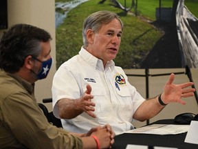 In this file photo taken on Aug. 29, 2020, Texas Gov. Greg Abbott, right, with U.S. Sen. Ted Cruz, attends a briefing for then-president Donald Trump in Orange, Texas. Abbott lifted a state mask mandate on March 2, 2021.