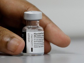 FILE PHOTO: A medical worker prepares to dilute a vial of Pfizer-BioNTech vaccine.