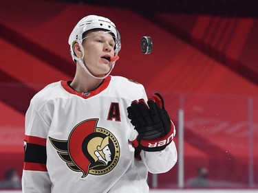 Senators forward Brady Tkachuk flips a puck to a linesman during the first period.