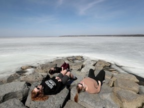 OTTAWA - March 23, 2021 -  Brooklyn Proulx, Victoria Davis and Alaira Soares relax on the sun filled rocks waiting for the ice to melt at Britannia Beach in Ottawa Tuesday.