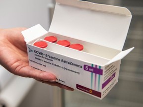 A health care worker handles a box of the AstraZeneca Plc Covid-19 vaccine vials at the Lux Med oncology hospital in Warszawa, Poland, on Thursday, Feb. 25, 2021.