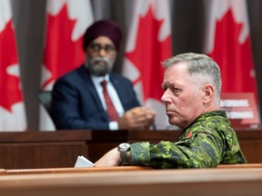 Canada's Defence Minister Harjit Sajjan and former chief of defence staff Jonathan Vance listen to a question during a news conference in Ottawa on Friday, June 26, 2020.