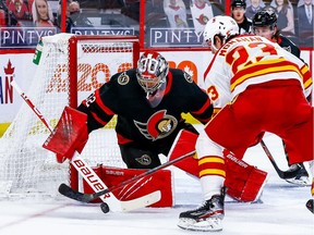 Ottawa Senators goaltender Filip Gustavsson makes a save against Calgary Flames centre Sean Monahan during second-period action at the Canadian Tire Centre.