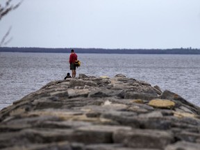 OTTAWA - April 11, 2021 - People fish off the end of the stone break wall at in Britannia Park Sunday, April 11, 2021. Ottawa is currently in stay-at-home orders issued by the province as the COVID-19 infections rise, setting records this weekend.