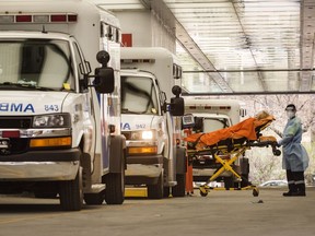 File photo/ Ambulance crew members deliver a patient a hospital.