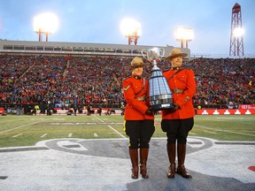 RCMP officers escort the Grey Cup championship trophy onto the field during the 107th Grey Cup Canadian Football League championship game in Calgary on Nov. 24, 2019.