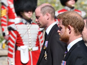 Prince William, Duke of Cambridge; Prince Harry, Duke of Sussex and Peter Phillips walk behind Prince Philip, Duke of Edinburgh's coffin, carried by a Land rover hearse, in a procession during the funeral of Prince Philip, Duke of Edinburgh at Windsor Castle on Saturday in Windsor, United Kingdom.