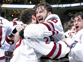 Jake Gaudet celebrates with teammate Marc Del Gaizo (No. 2) of the Massachusetts Minutemen after a 5-0 victory over the St. Cloud St. Huskies at PPG Paints Arena on April 10, 2021, in Pittsburgh.