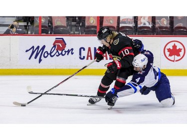 Ottawa Senators left wing Ryan Dzingel (left) gets hauled down Winnipeg Jets defenceman Neal Pionk during first period NHL action at the Canadian Tire Centre.