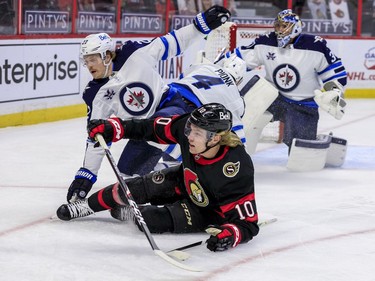 Ottawa Senators left wing Ryan Dzingel (10) gets hauled down by Winnipeg Jets centre Mason Appleton (22) in front of Winnipeg Jets goaltender Connor Hellebuyck (37) during first period NHL action at the Canadian Tire Centre.