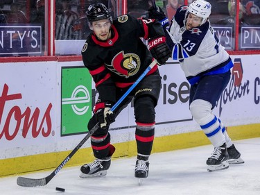 Ottawa Senators defenceman Artem Zub (left) moves the puck as Winnipeg Jets center Pierre-Luc Dubois pursues during second period NHL action at the Canadian Tire Centre.