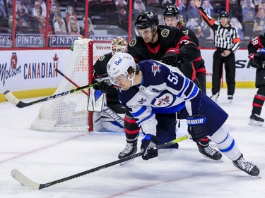 Ottawa Senators defenceman Josh Brown (3) checks Winnipeg Jets center Mark Scheifele (55) during second period NHL action at the Canadian Tire Centre.