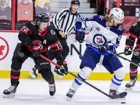 Ottawa Senators defenceman Thomas Chabot (left) checks Winnipeg Jets left wing Kyle Connor during second period NHL action at the Canadian Tire Centre.