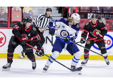 -OTTAWA- April 12,2021. Ottawa Senators defenseman Thomas Chabot (72) checks Winnipeg Jets left wing Kyle Connor (81) during second period NHL action at the Canadian Tire Centre. ERROL MCGIHON/Postmedia