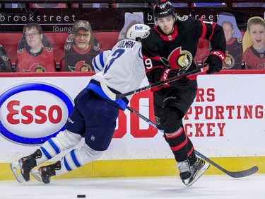 -OTTAWA- April 12,2021. Ottawa Senators right wing Drake Batherson (19) avoids the check of Winnipeg Jets defenseman Tucker Poolman (3) during third period NHL action at the Canadian Tire Centre. ERROL MCGIHON/Postmedia