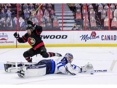 -OTTAWA- April 12,2021. Ottawa Senators right wing Evgenii Dadonov (63) gets poke-checked by Winnipeg Jets goaltender Connor Hellebuyck (37) during third period NHL action at the Canadian Tire Centre. ERROL MCGIHON/Postmedia