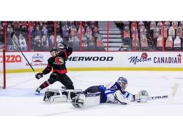 -OTTAWA- April 12,2021. Ottawa Senators right wing Evgenii Dadonov (63) gets poke-checked by Winnipeg Jets goaltender Connor Hellebuyck (37) during third period NHL action at the Canadian Tire Centre. ERROL MCGIHON/Postmedia