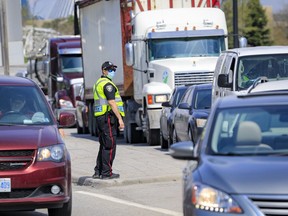 An Ottawa Police Service officer monitors traffic on King Edward Avenue in Ottawa after crossing into Ontario from Quebec via the on the Macdonald-Cartier Bridge.
