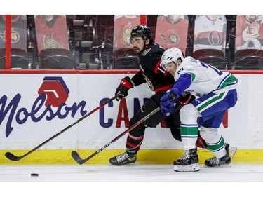 Ottawa Senators left wing Nick Paul (13) battles Vancouver Canucks defenceman Travis Hamonic (27) during first period NHL action at the Canadian Tire Centre on monday.
