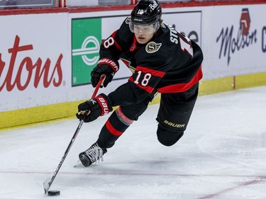 Ottawa Senators left wing Tim Stuetzle (18) controls a loose puck against the Vancouver Canucks at the Canadian Tire Centre on Monday.