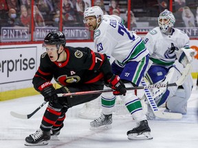 Ottawa Senators winger Brady Tkachuk (7) and Vancouver Canucks defenceman Alexander Edler  in front of goaltender Braden Holtby on Monday night at the Canadian Tire Centre.