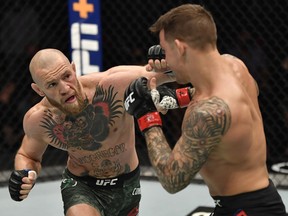 Conor McGregor punches Dustin Poirier in a lightweight fight during UFC 257 inside Etihad Arena on UFC Fight Island.