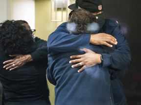 People hug after learning that their loved one is safe after a shooting inside a FedEx building Friday, April 16, 2021.
