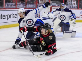 Senators forward Ryan Dzingel (10) is hauled down by Winnipeg Jets center Mason Appleton  during the first period on Monday night at the Canadian Tire Centre.