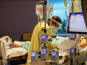 A respiratory therapist checks a COVID-19 patient inside the intensive care unit of Humber River Hospital in Toronto, April 15, 2021.