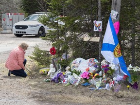 A woman pays her repects at a roadblock in Portapique, N.S. on Wednesday, April 22, 2020.