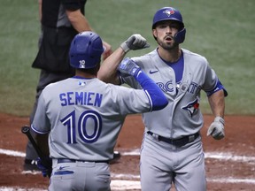 Blue Jays centre fielder Randal Grichuk (right) is congratulated by shortstop Marcus Semien (left) after he hit a home run during the sixth inning against the Rays at Tropicana Field in St. Petersburg, Fla., Friday, April 23, 2021.