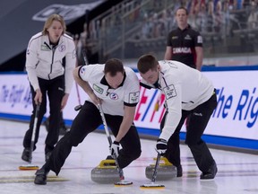 Team RCF skip Sergey Glukhov (left) follows his sweepers during his team's Draw 17 win over Canada at the world men's curling championship in Calgary.