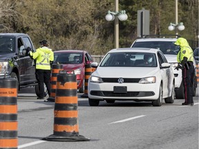 Ottawa police officers screen travellers crossing the Chaudiere Bridge from Quebec into Ontario on Monday.