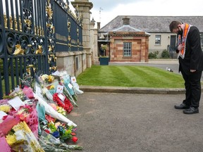A man bows in front of flowers placed at Hillsborough Castle after Britain's Prince Philip, husband of Queen Elizabeth, died at the age of 99, in Hillsborough, Northern Ireland, April 10, 2021. REUTERS/Jason Cairnduff ORG XMIT: GDN
