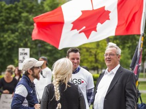 Randy Hillier, Ontario MPP for Lanark-Frontenac-Kingston, right, chats with participants before speaking at the Toronto Freedom Rally to End the State of Emergency held at the step of Queen's Park in Toronto, Ont. on Tuesday June 2, 2020.