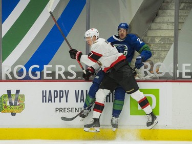 Ottawa Senators forward Brady Tkachuk (7) checks Vancouver Canucks defenseman Travis Hamonic (27)  in the first period at Rogers Arena.