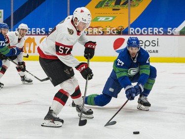 Apr 24, 2021; Vancouver, British Columbia, CAN; Vancouver Canucks defenseman Travis Hamonic (27) checks Ottawa Senators forward Shane Pinto (57) in the third period at Rogers Arena. Canucks won 4-2.  Mandatory Credit: Bob Frid-USA TODAY Sports ORG XMIT: IMAGN-445658