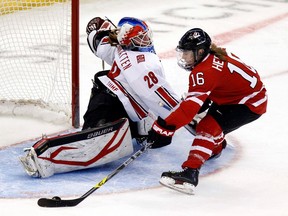 Canada's Jayna Hefford (right) scores on Switzerland's goalie Sophie Anthamatten during the second period of their preliminary round game at the IIHF Ice Hockey Women's World Championship in Ottawa April 3, 2013.