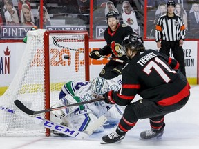 Vancouver Canucks goaltender Thatcher Demko makes a save off of Ottawa Senators centre Chris Tierney (71) as right wing Connor Brown (28) follows the play, April 28, 2021.