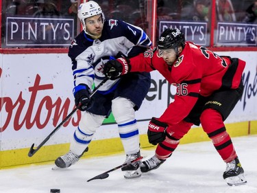Ottawa Senators centre Colin White (36) battles with Winnipeg Jets defenceman Dylan DeMelo (2).