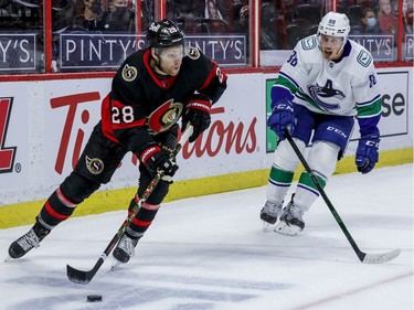 Ottawa Senators right wing Connor Brown (28) eludes the check of Vancouver Canucks defenceman Nate Schmidt.