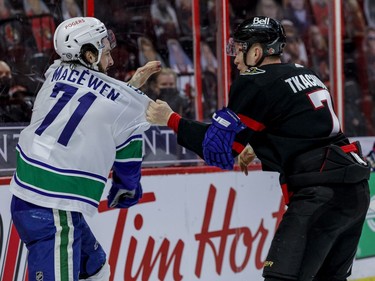 Ottawa Senators left wing Brady Tkachuk (7) fights with Vancouver Canucks centre Zack MacEwen.