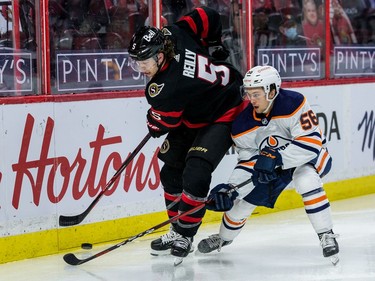 Ottawa Senators defenceman Mike Reilly (5) keeps the puck away from Edmonton Oilers right wing Kailer Yamamoto.