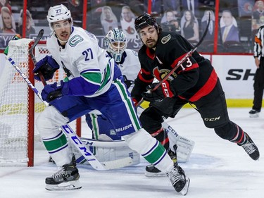 Ottawa Senators left wing Nick Paul (13) battles against Vancouver Canucks defenceman Travis Hamonic.