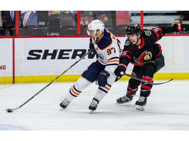 Ottawa Senators defenceman Mike Reilly (5) attempts to check Edmonton Oilers centre Connor McDavid.