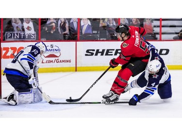 Ottawa Senators left wing Alex Formenton (59) is stopped on a partial breakaway by Winnipeg Jets goaltender Laurent Brossoit (30) as defenceman Neal Pionk (4) checks.